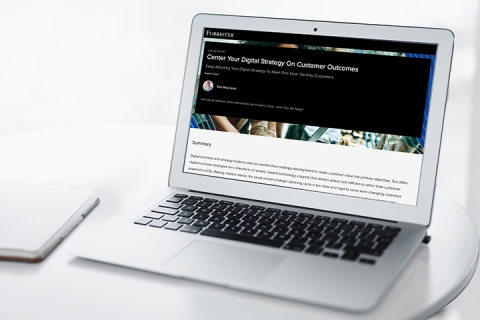 Laptop with Forrester report displayed on-screen