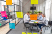 Business people meeting and brainstorming in an office. Use of sticky notes to post and share ideas