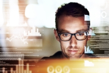 man working on his computer late at night with graphs and code