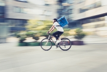 Food delivery person on bicycle going fast with blurry background