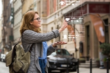 Augmented reality in marketing. Woman traveler with phone. Navigation on the projection of the display