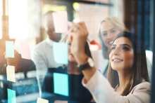 Menschen machen Notitzen auf einem durchsichtigen Board