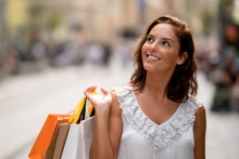 woman shopping outdoor holding bags and smiling
