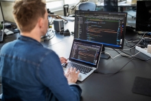 Ingénieur logiciel écrivant du code sur un ordinateur portable et de bureau à des fins de programmation d’automatisation