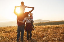 a family on a hill under the sunset