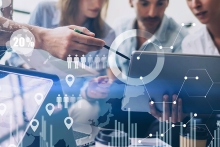 Digital icons floating in front of a computer and people working