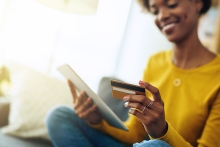 Jeune femme à l'aide d'une tablette numérique tout en effectuant un paiement pour une facture