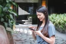 Image of Young Businesswoman using smart phone with financial charts, mobile, tablet, interactive tables, documents