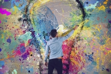 Boy draws with a brush an abstract big light bulb.