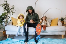 Happy child and young father with inflatable ring and drawing tropical fishes around him