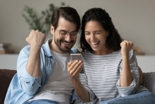 Couple excited and looking at their smartphone