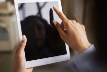 Close up of womans hands using tablet touchscreen