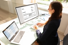 Femme d'affaires qui travaille au bureau avec des factures electroniques