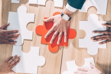 overhead view of multiracial businesspeople assembling puzzle on table