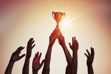 hands holding up a trophy