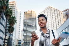 young businesswoman using a mobile phone on the go in the city