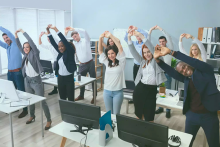 Business people stretching in unison in office