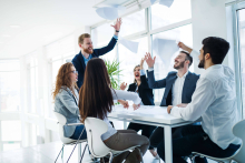 Office workers throwing papers in the air
